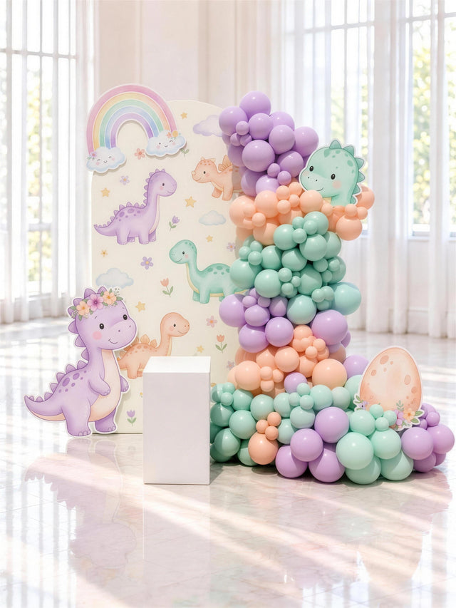 Décor d'anniversaire au thème dinosaures en pastel, backdrop et guirlande de ballons, livré et installé par Fête ta Fête