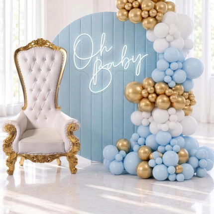 Decor bleu pastel avec toile de fond ronde en velours, trone royal blanc et or et guirlande de ballons