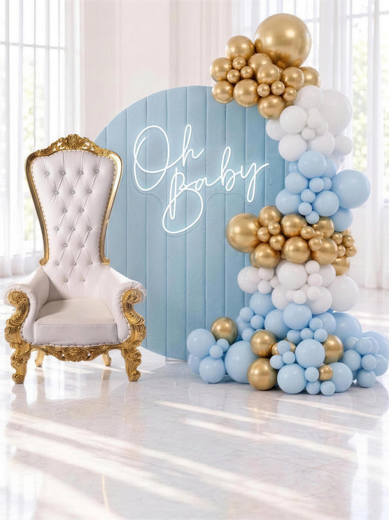 Decor bleu pastel avec toile de fond ronde en velours, trone royal blanc et or et guirlande de ballons